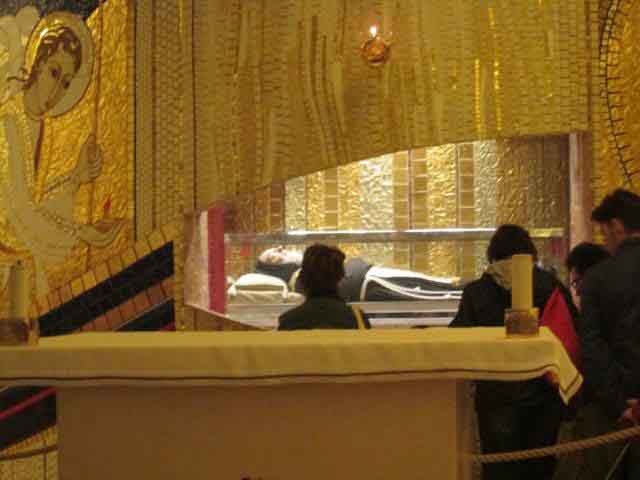 Praying before the incorrupt body of Saint Padre Pio