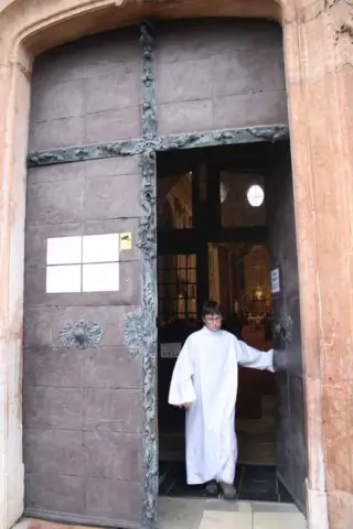 Opening the door at the start of the procession at Our Lady of Sorrows Basilica in Sastin Slovakia